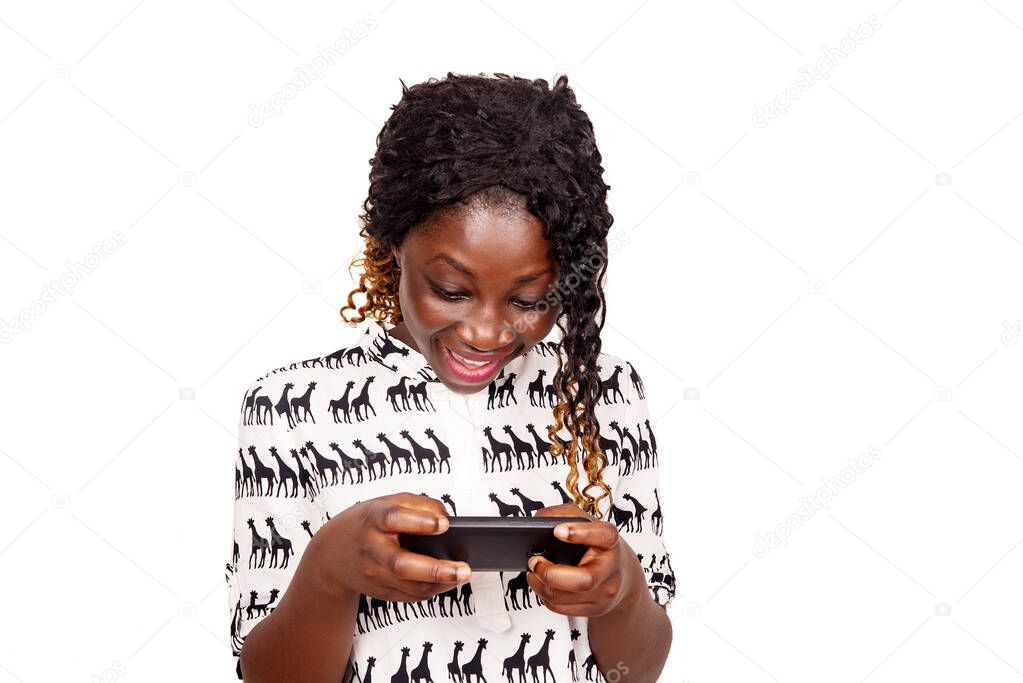beautiful confident and serious young woman playing game on her mobile phone, and smiling isolated on white background.
