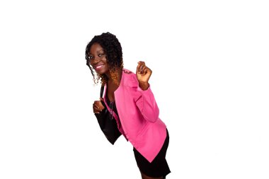 Pembe ceketli, siyah elbiseli, gülümseyen bir kadın.