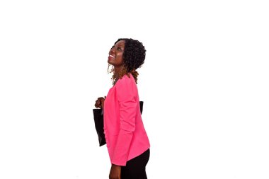 Pembe ceketli, kıvırcık saçlı, poz veren ve gülümseyen güzel bir genç kadın.