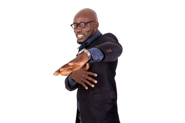 Takım elbiseli genç işadamı beyaz arka planda duruyor jestler yapıyor ve gülümseyen kameraya bakıyor..