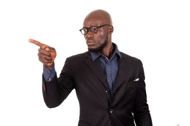 Beyaz arka planda duran takım elbiseli genç işadamı havadan hoşnutsuzluğu gösteriyor..