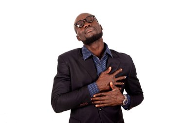 Beyaz arka planda duran takım elbiseli yakışıklı genç bir işadamı şok olmuş gibi görünüyor..