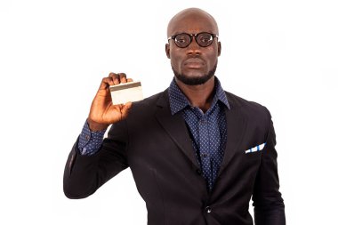 Genç yakışıklı iş adamı beyaz arka planda gözlüklerle duruyor ve bir kredi kartı sunuyor..