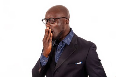 Beyaz arka planda takım elbiseli genç ve yakışıklı iş adamı esnemekten yoruldu..