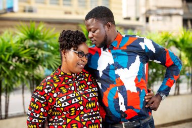 Dışarıda dikilen güzel çift gülümserken birbirleriyle konuşuyorlar.