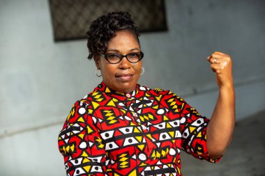 Dışarıda oturan güzel bir kadın kol kaslarını gösteriyor.