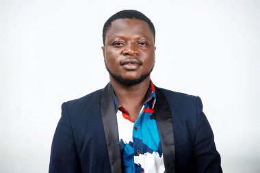 Takım elbiseli yakışıklı genç işadamı kameraya bakıp gülümsüyor.