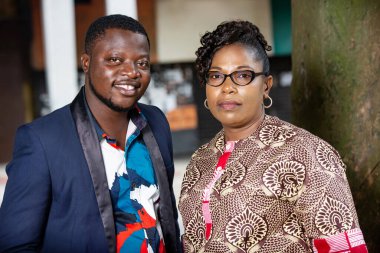 Güzel, genç, romantik bir çift sokakta kameraya bakıp gülümserken poz veriyor.