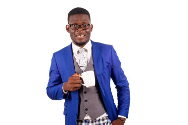 Ceketli genç işadamı beyaz arka planda tek başına elinde bir fincan kahveyle kameraya bakıp gülümsüyor.