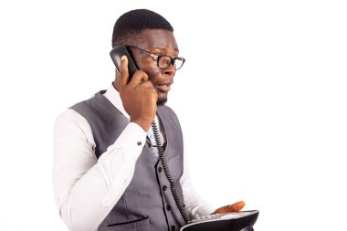 Gözlüklü yakışıklı genç işadamı siyah bir cep telefonu tutuyor ve bir arama yapıyor..