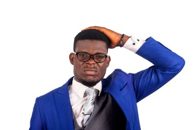 Yakışıklı genç iş adamının portresi stresli ve çaresiz, gözlüklü ve mavi ceketli, kameraya bakıyor, dehşete düşmüş ve şokta, ağzını sonuna kadar açık tutuyor, ellerini kafaya dayıyor..