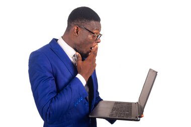 Ceketli yakışıklı bir işadamı beyaz bir arka planda tek başına dizüstü bilgisayara bakarken şaşırdı.