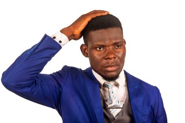 Çekici genç bir iş adamı beyaz arka planda durup kafasına dokunarak düşünür.