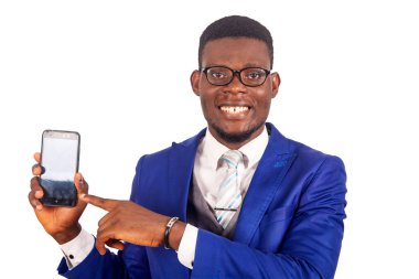 Mavi ceketli yakışıklı genç işadamı cep telefonunu sunuyor ve siyah bir ekranı işaret ediyor.