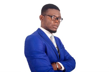 Gözlüklü şık takım elbiseli genç bir işadamı kameraya bakıyor.