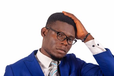 Beyaz takım elbiseli bir iş adamı kameraya el ele baktığını düşünüyor.