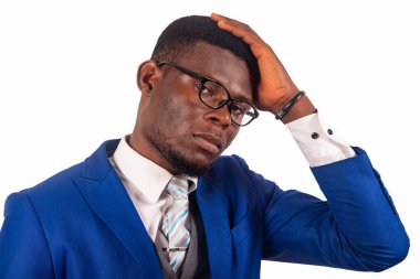 Beyaz takım elbiseli bir iş adamı kameraya el ele baktığını düşünüyor.