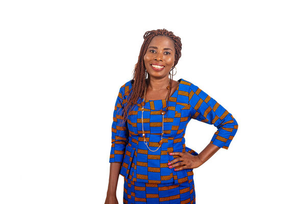 beautiful African businesswoman in traditional dress standing on white background hand on hip smiling to look at camera