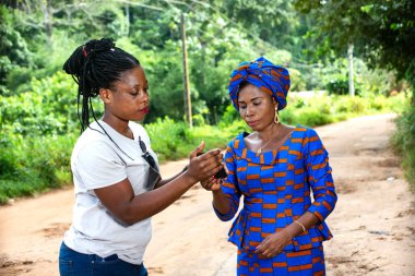 Doğada cep telefonu kullanan iki güzel yetişkin kadın..