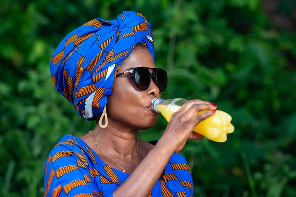 田舎の飲み物ジュースに身を包んだアフリカ系の美しい女性が — ストック写真