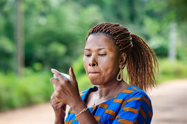 Vacker Afrikansk Kvinna Traditionell Klänning Stående Landsbygden Stirrar Liten Spegel — Stockfoto