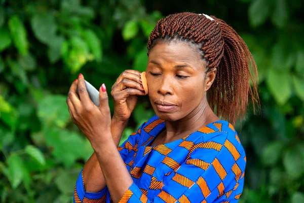 African Woman Traditional Dress Standing Countryside Applying Foundation Small Mirror — Stock Photo, Image