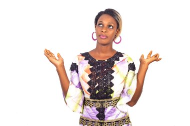 Güzel genç bir kadın elini kaldırıyor ve yukarı bakıyor, beyaz arka planda soyutlanmış.