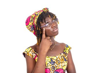 Güzel, ciddi, genç bir kadın gözlük takıyor ve gözleri havada düşünüyor..