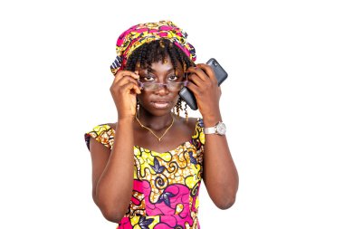 Güzel, ciddi, gözlüklü, elinde cep telefonu olan ve kameraya bakan genç bir kadın..