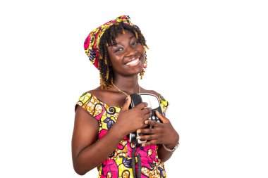 Güzel genç bir kadın cep telefonuyla el ele tutuşup kameraya gülümsüyor..