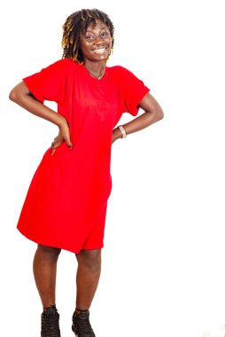 Kırmızı elbiseli güzel bir kadın ellerini kalçasında tutuyor ve kameraya gülümsüyor..