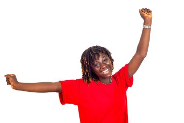 Beyaz arka planda kırmızı elbiseli güzel bir kadın kollarını kaldırıp kameraya gülümseyen bir jest yapıyor..