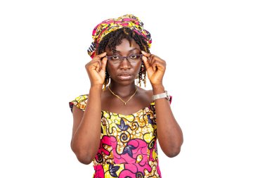 Güzel, ciddi, genç bir kadın gözlük takıyor ve çerçeveyi tutuyor..