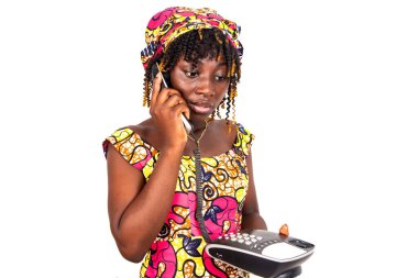 Geleneksel peştemalli güzel ve ciddi bir kadın cep telefonuyla konuşuyor.