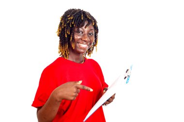 Güzel genç bir iş kadını kırmızı tişörtlü, belgeyi gösteriyor ve gülümseyen kameraya bakıyor.