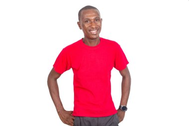 Kırmızı tişört giyen, elleri ceplerinde kameraya gülümseyen yetişkin bir iş adamının portresi..