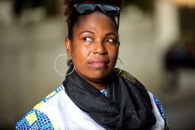 Boynuna fular dolanmış, sokakta yan bakan olgun bir iş kadını..