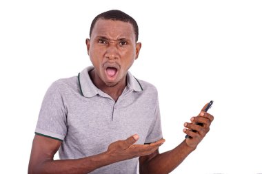 Cep telefonu tutan genç adam, ağzı açık, şok olmuş görünüyor..