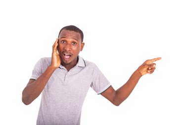 Genç adam içeride duruyor, ağzı açık, ağzı açık bir şekilde yan parmağı işaret ediyor..