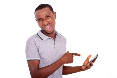 Yakışıklı, öfkeli genç adam içeride durmuş cep telefonu ekranını işaret ediyor..