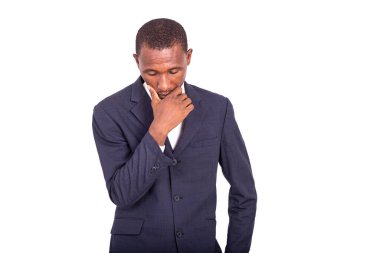 Ceketli yakışıklı iş adamı beyaz arka planda duruyor ve kafası aşağıda düşünüyor..