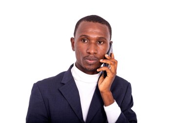 Beyaz arka planda duran ceketli yakışıklı bir işadamı cep telefonuyla konuşuyor..