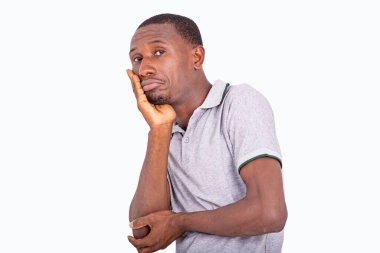 Hayal kırıklığına uğramış ve mutsuz genç bir adam. Şaşırmış bir yüz ifadesi var. Elleri ve yanakları çaprazlanmış..