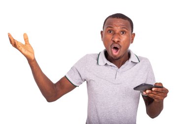 Yakışıklı genç adam içeride duruyor, şaşırmış görünüyor, ağzı açık bir şekilde cep telefonu tutuyor..