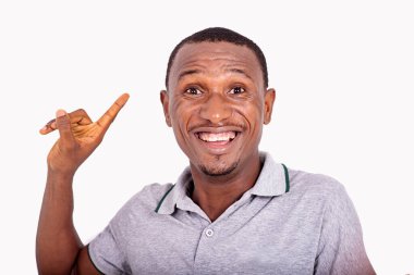 Yakışıklı, genç ve mutlu bir adam içeride durmuş, parmağını kaldırıyor ve kameraya gülümsüyor..