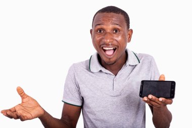 Cep telefonu tutan ve kameraya gülümseyen yakışıklı genç adam..