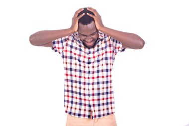 Yakışıklı, ciddi, yetişkin bir adam. İki eli başının üstünde duruyor ve baş ağrısı çekiyor..