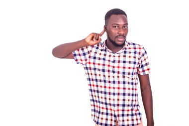 Yakışıklı, ciddi, yetişkin bir adam tişörtünü giymiş, parmaklarını kulağına dayayıp dedikoduları dinliyor..