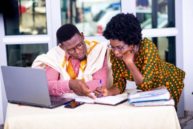 İşadamı ve iş kadını laptopta çalışıyor ve ofiste raporları birlikte kontrol ediyorlar..