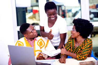 Yetişkin iş ortakları not defterindeki raporları kontrol etmeye ve ofiste birlikte parmak kaldırmaya çalışıyorlar..